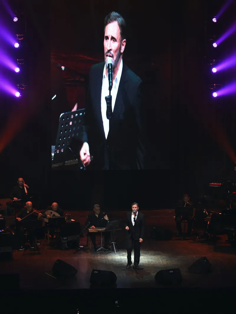 Kadim Al Sahir on stage at Haliç Congress Center with his image on the big screen above the orchestra
