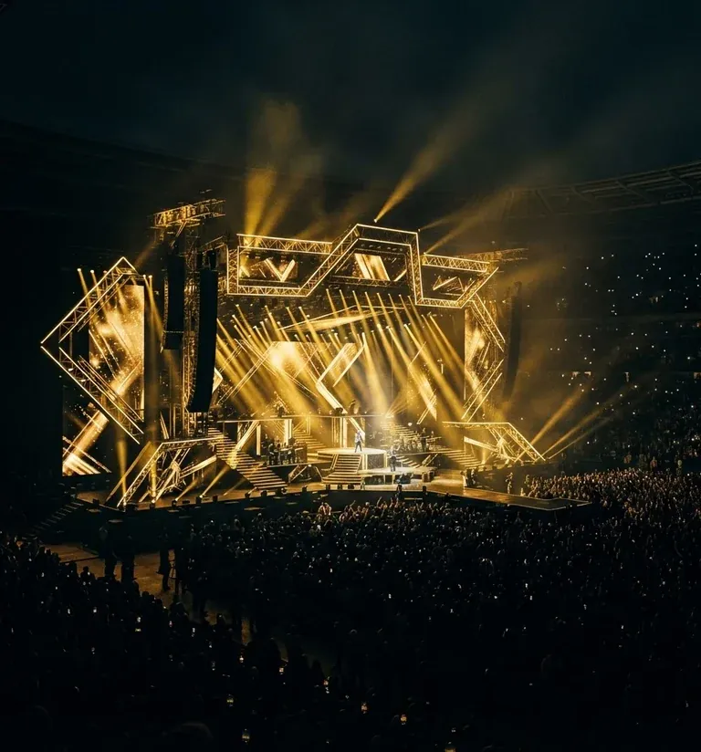 Gold-lit stage architecture for a large event